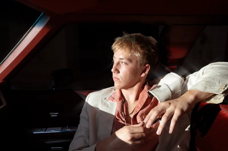 Man seated in a red car